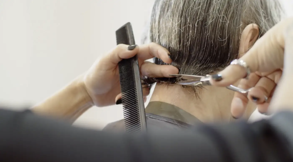 elderly person getting a hair cut