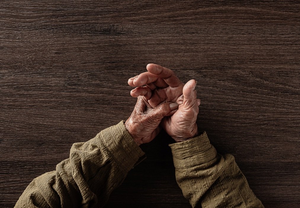 Hands of an elderly on a table
