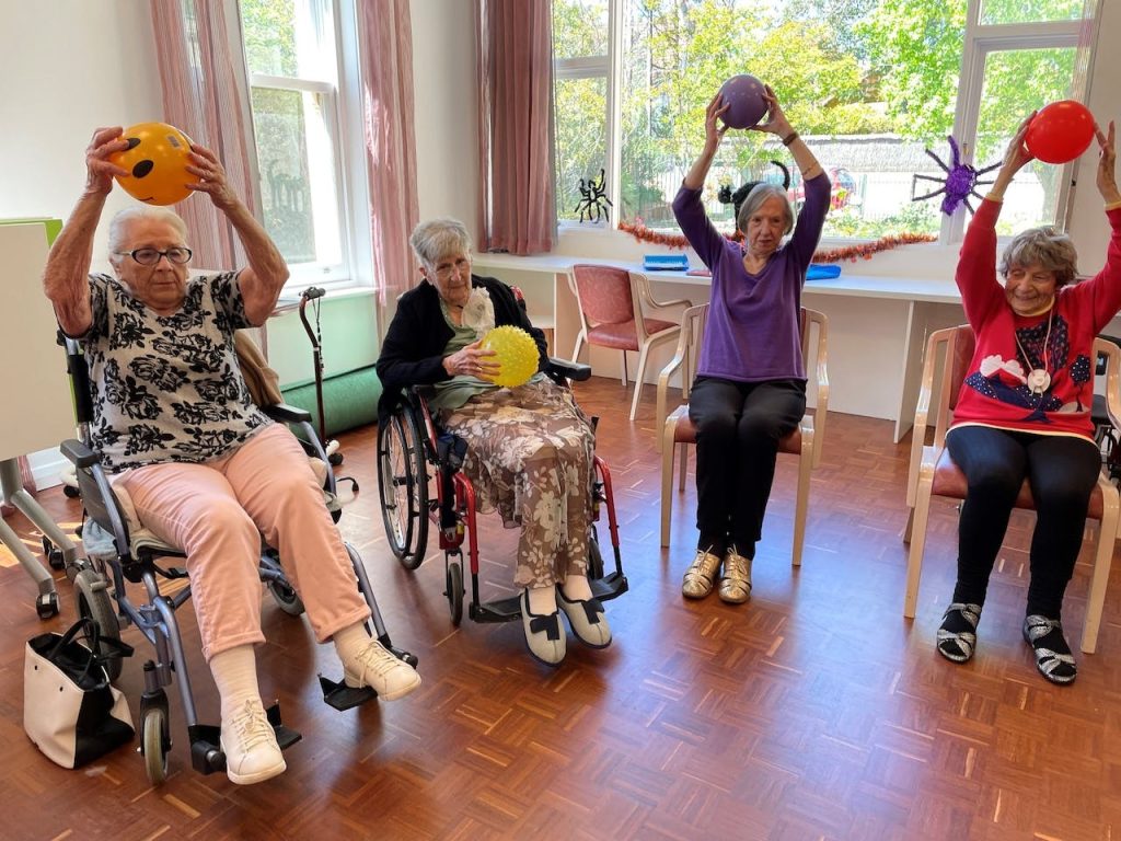 Elder people playing an indoor game with ball.